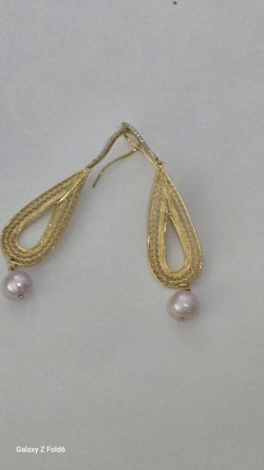Pair of earrings with teardrop filigree motifs and pale hanging accents